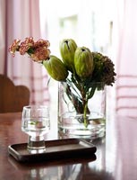 Carnations and Protea buds in glass vase