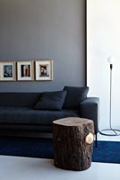 Contemporary grey sofa and log side table

