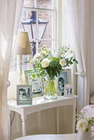 Low table with display of photos and Roses in vase