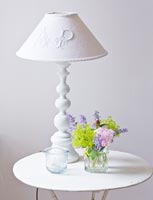 White lamp and flowers on vintage table