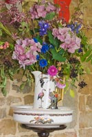 Colourful flowers including Hydrangea and Cornflowers in patterned jug