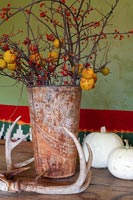 Arrangement of Crabapples and berries in rusty vase