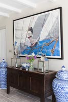 Nautical painting above wooden sideboard