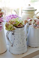Hydrangea flowers in enamel jugs