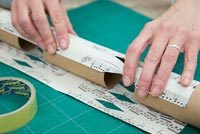 Step by Step guide for making Christmas Crackers from scratch - wrapping cracker material around toilet rolls