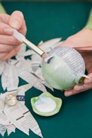 Create a simple Christmas bauble using newspaper - adding glue to bauble