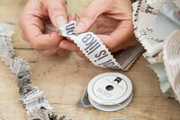 Creating a simple Christmas wreath using newspaper and  wire - threading newspaper onto string