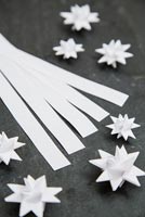 Using paper strips to create star shaped decorations -  materials needed