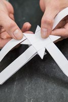 Using paper strips to create star shaped decorations - folding each strip in half again