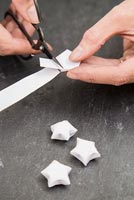 Using paper strips to create star shaped decorations - trimming excess paper away