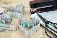 Creating a heart shaped decoration using newspaper and coloured thread - finished shot with materials used