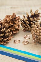 Making christmas decorations with pine cones and ribbon