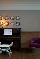 Patterned plates hung above piano