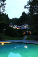 Country garden with pool lit up at night