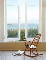 Wooden rocking chair by window