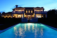 Classic house and swimming pool lit up at night