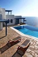 Traditional greek house and pool overlooking sea