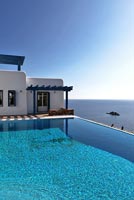 Traditional greek house and pool overlooking sea