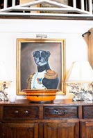 Dog painting hug above wooden cabinet