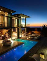 Contemporary house and pool lit up at night