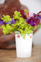 Posy of Ladys mantle and Sweet pea flowers in white beaker