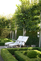 Formal parterre garden with white loungers