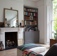 Grey bookcase by fireplace