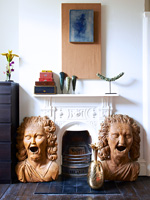 Carved figures by fireplace