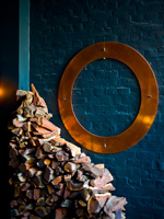 Copper sculpture mounted on exposed brick wall