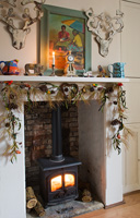 Log burning stove with garland of conifer foliage