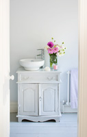 Bathroom sink with vase of Dahlias