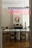 Modern dining room with designer furniture and pink suspended light by Johanna Grawunder
