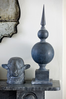 Lead finial and sheeps head ornaments on marble mantlepiece