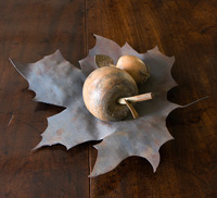 Wooden fruit ornaments on metal leaf shaped bowl