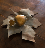 Wooden fruit ornaments on metal leaf shaped bowl