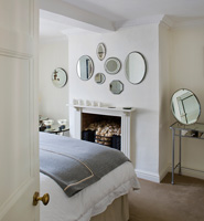 Collection of antique mirrors on bedroom wall