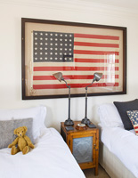 Vintage framed US flag above punched zinc fronted bedside cabinet