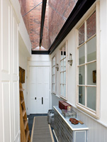 Narrow side entrance with glazed roof and painted seed chest