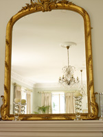Gold framed mirror on mantlepiece