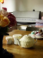 Crochet covered tableware on wooden dining table