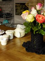 Crochet covered tableware on wooden dining table
