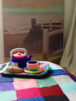 Crochet covered tea set on bed
