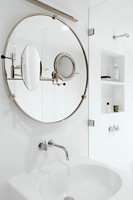Circular mirror above sink
