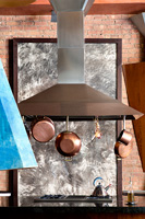 Copper pots and pans hanging from extractor hood