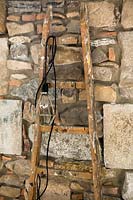 Wooden ladder against stone wall