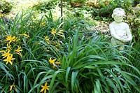Garden border with Daylilies and sculpture