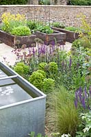 Colourful garden with raised vegetable beds and pond
