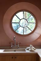 Circular window above kitchen sink