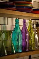 Colourful glassware on kitchen shelves