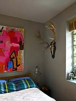 Colourful painting above bed